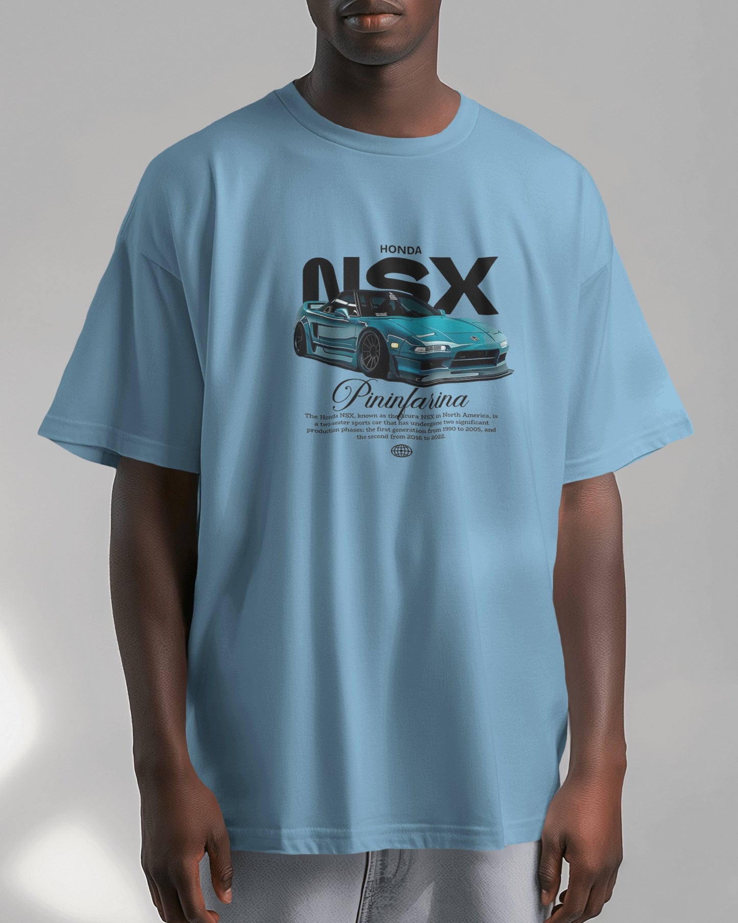 Person wearing a baby blue t-shirt with a car graphic and text on a plain background