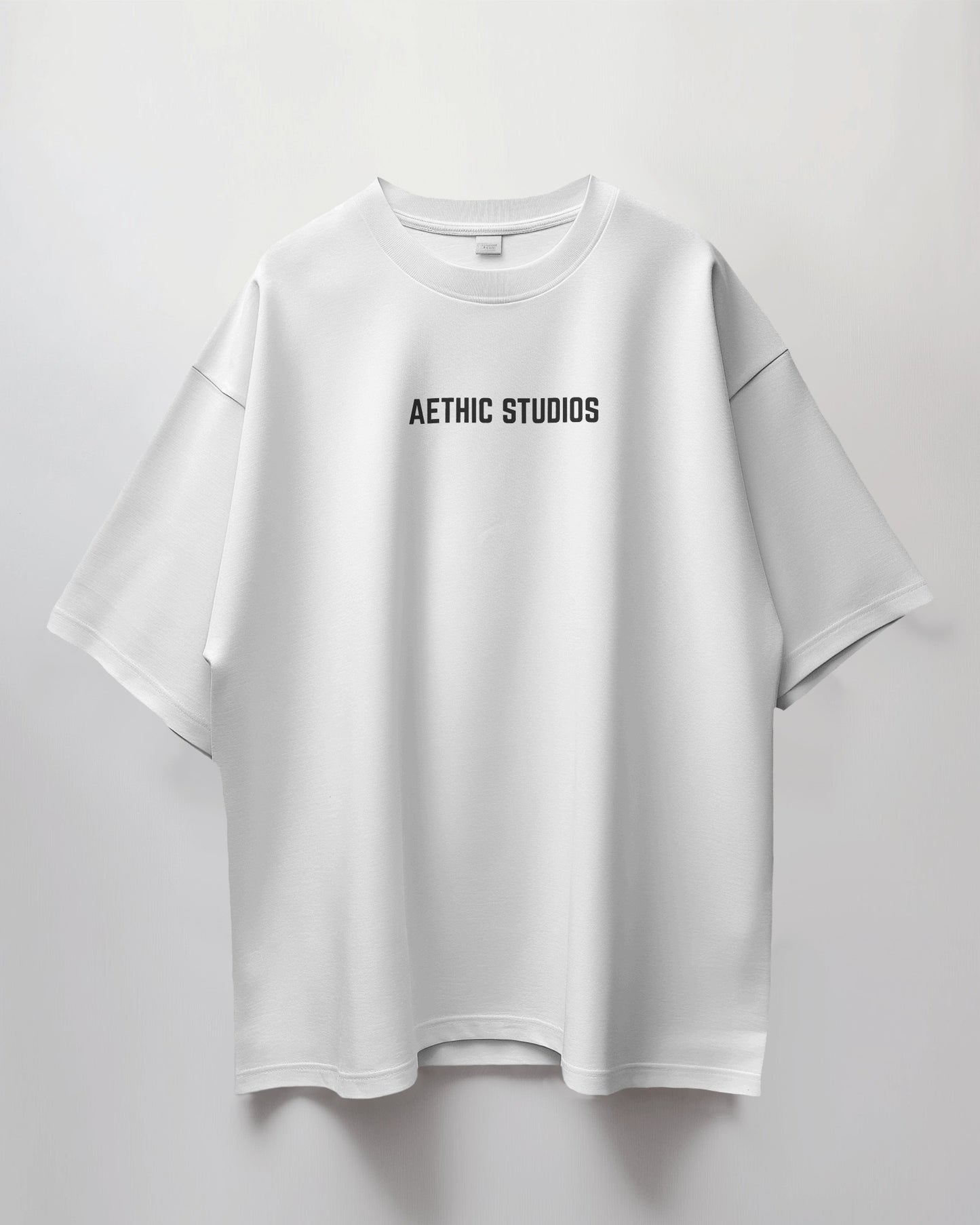 White t-shirt with 'Aethic Studios' text on a light gray background