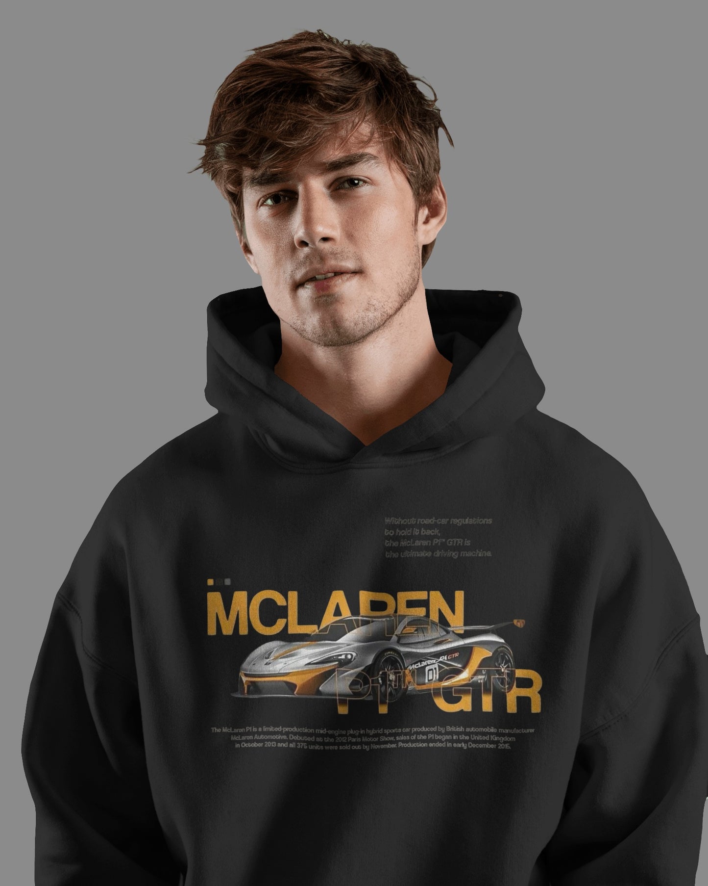 Person wearing a Colour_black hoodie with McLaren logo and car design on a gray background