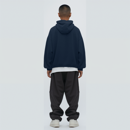 Person wearing a Navy blue hoodie and dark pants on backgrounda light gray 