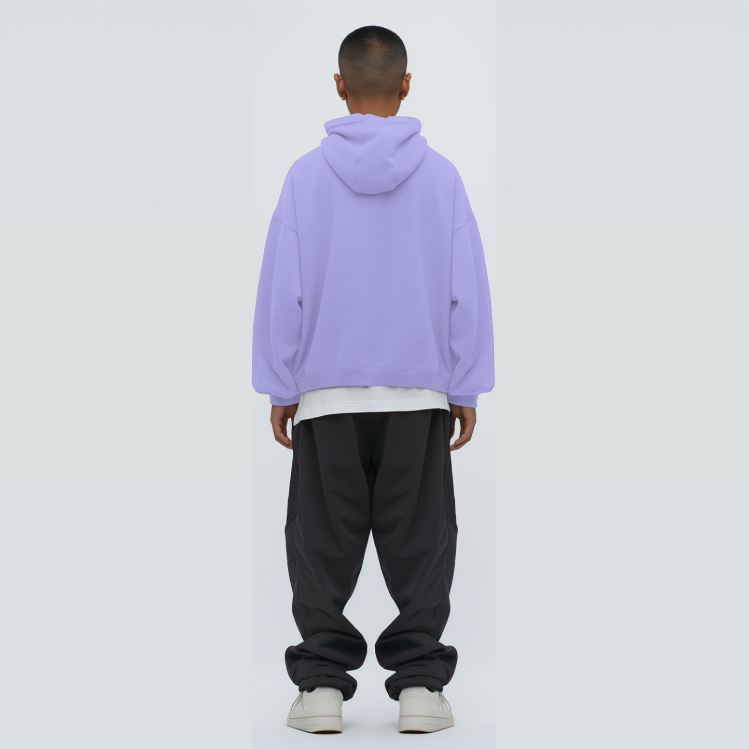 Person wearing a lavender hoodie and dark pants on a white background