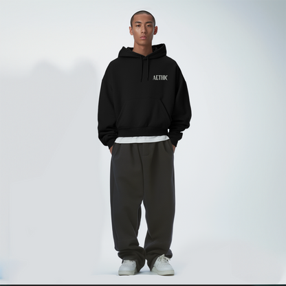 Person wearing a black hoodie with 'Aethic' branding on a white background