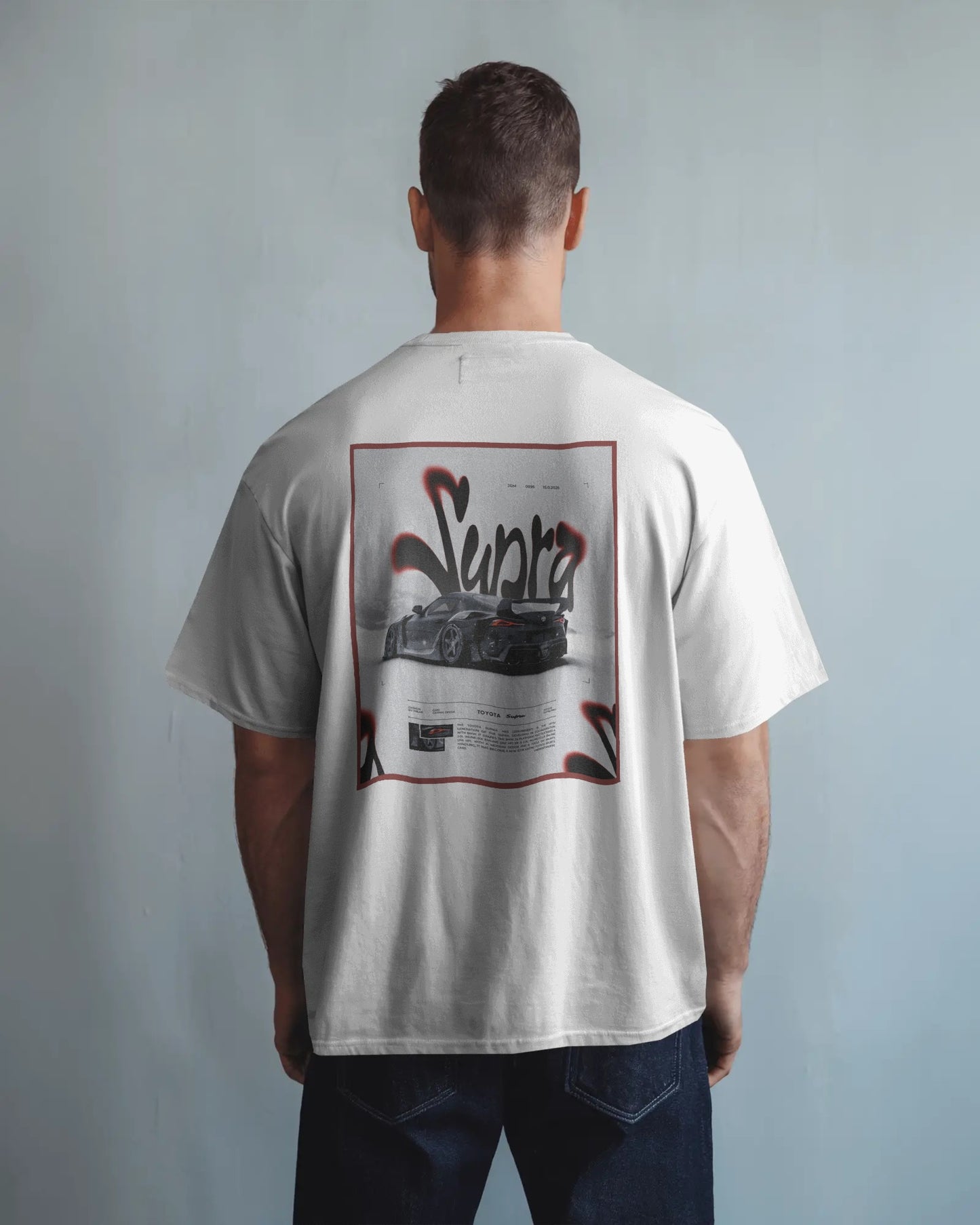Person wearing a Colour_White t-shirt with a graphic design on the back against a plain background