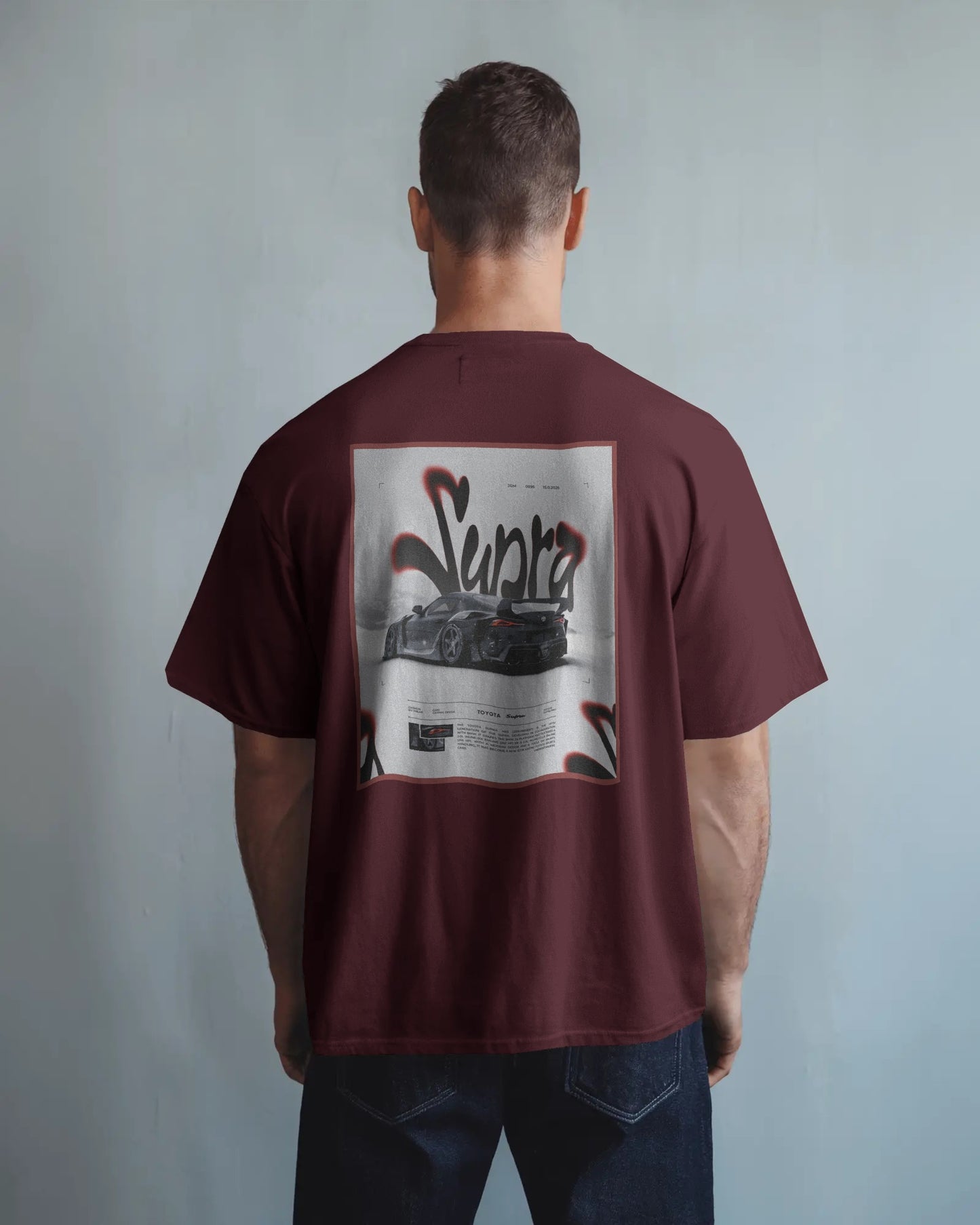Man wearing a Colour_Maroon t-shirt with a graphic design on the back against a plain background