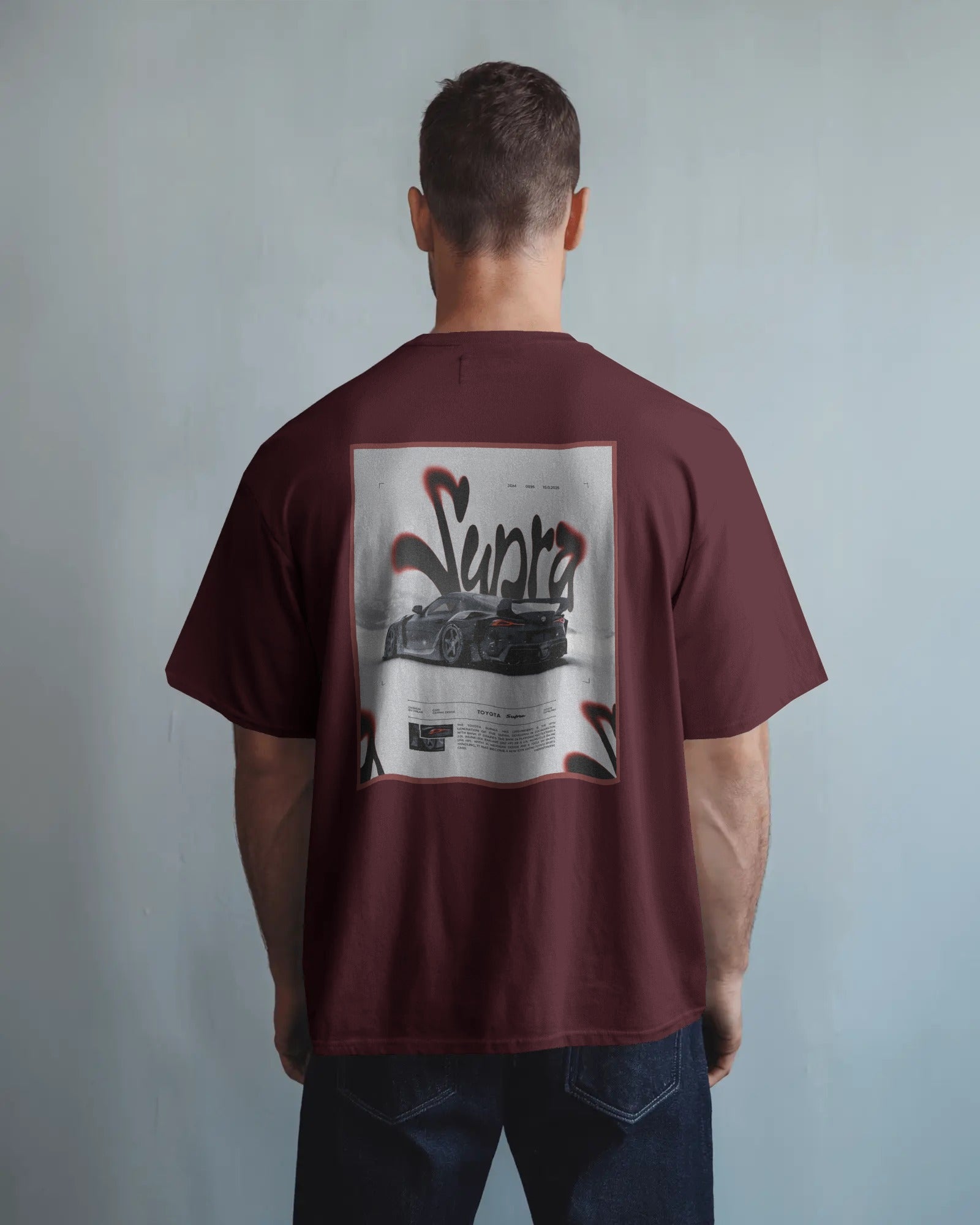 Man wearing a Colour_Maroon t-shirt with a graphic design on the back against a plain background