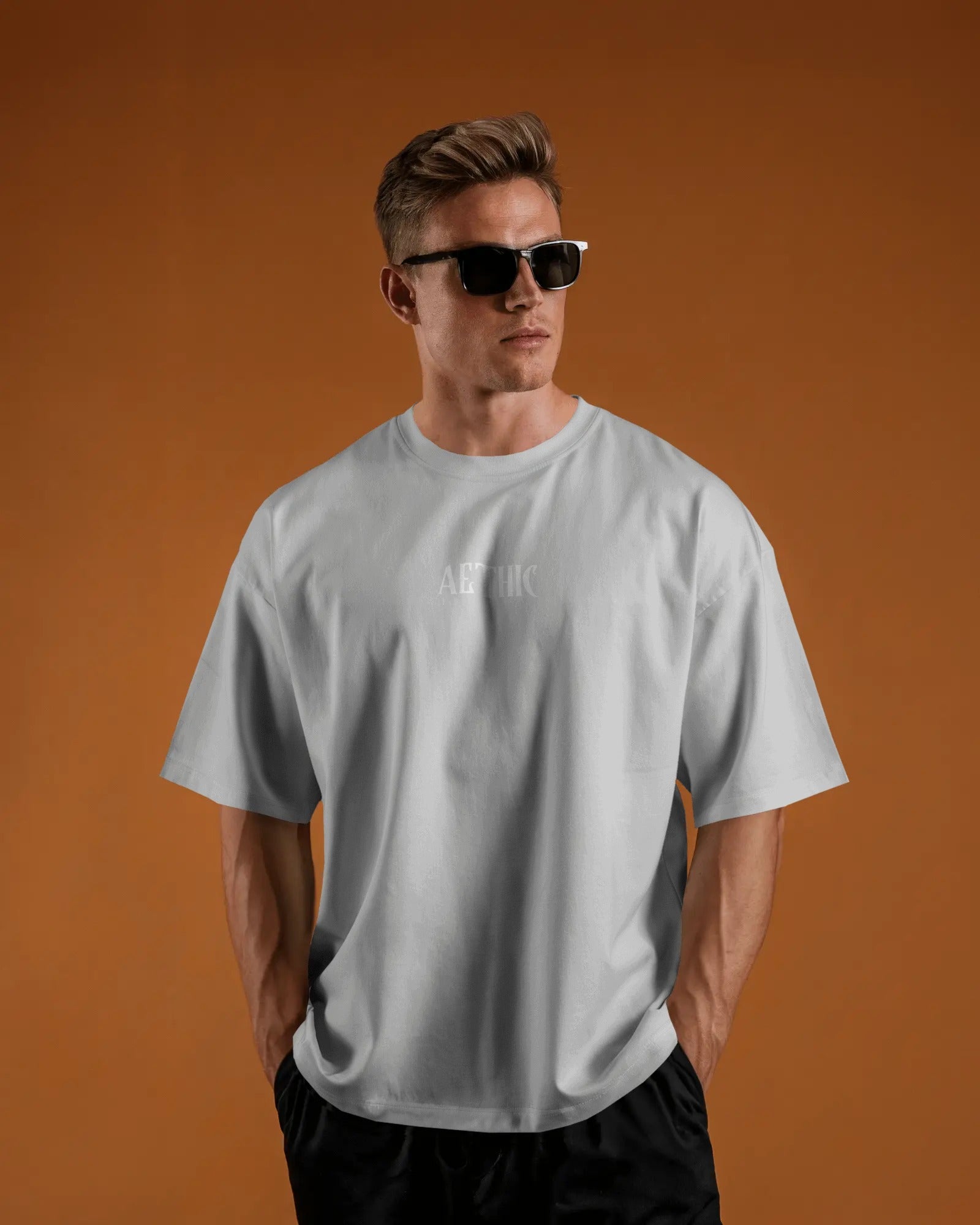 Man wearing a Colour_White t-shirt with a logo on an orange background