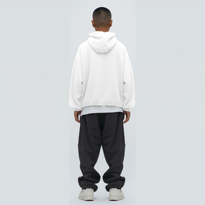 Person wearing a white hoodie and black pants on a light gray background