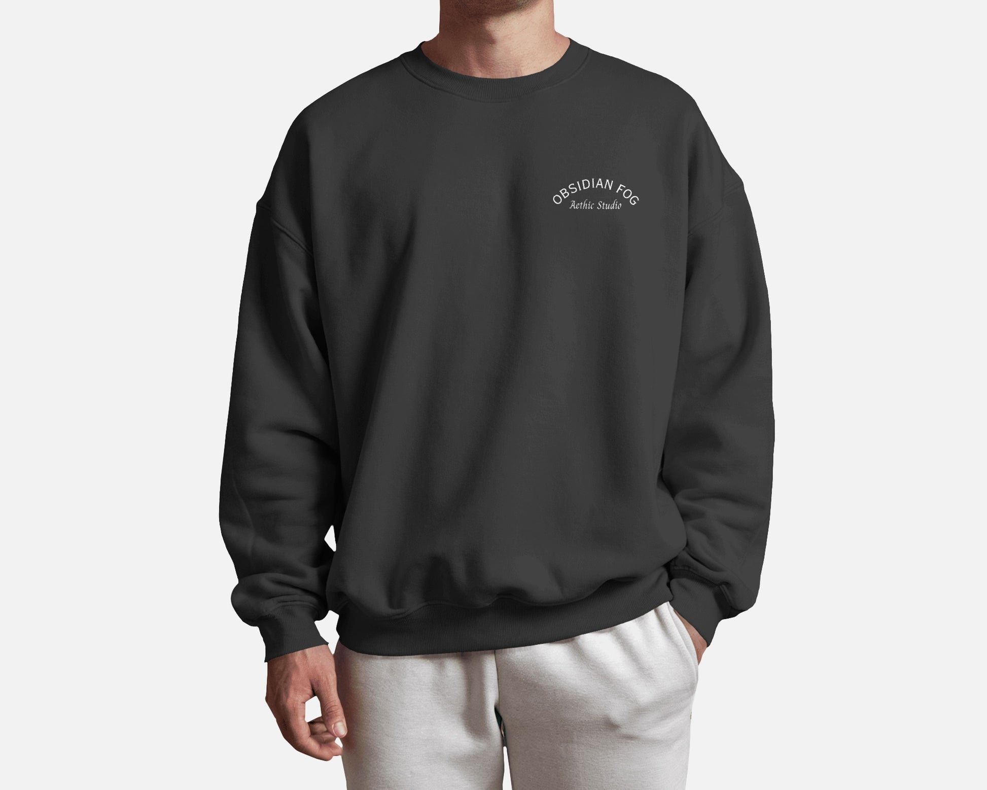 Male model wearing Obsidian Fog graphic sweatshirt in dark green color by Aethic Studios