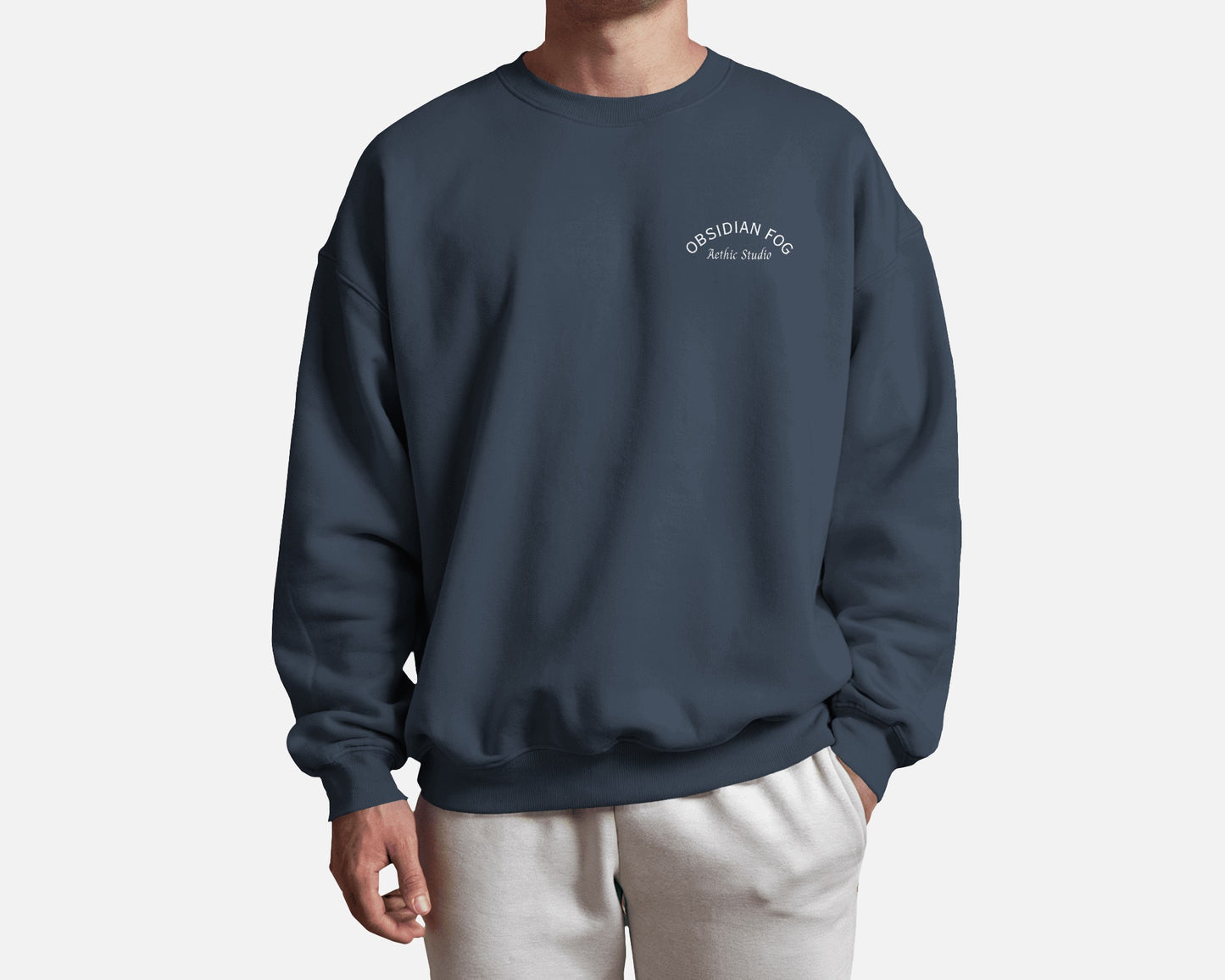 Male model wearing Obsidian Fog graphic sweatshirt in dark green color by Aethic Studios