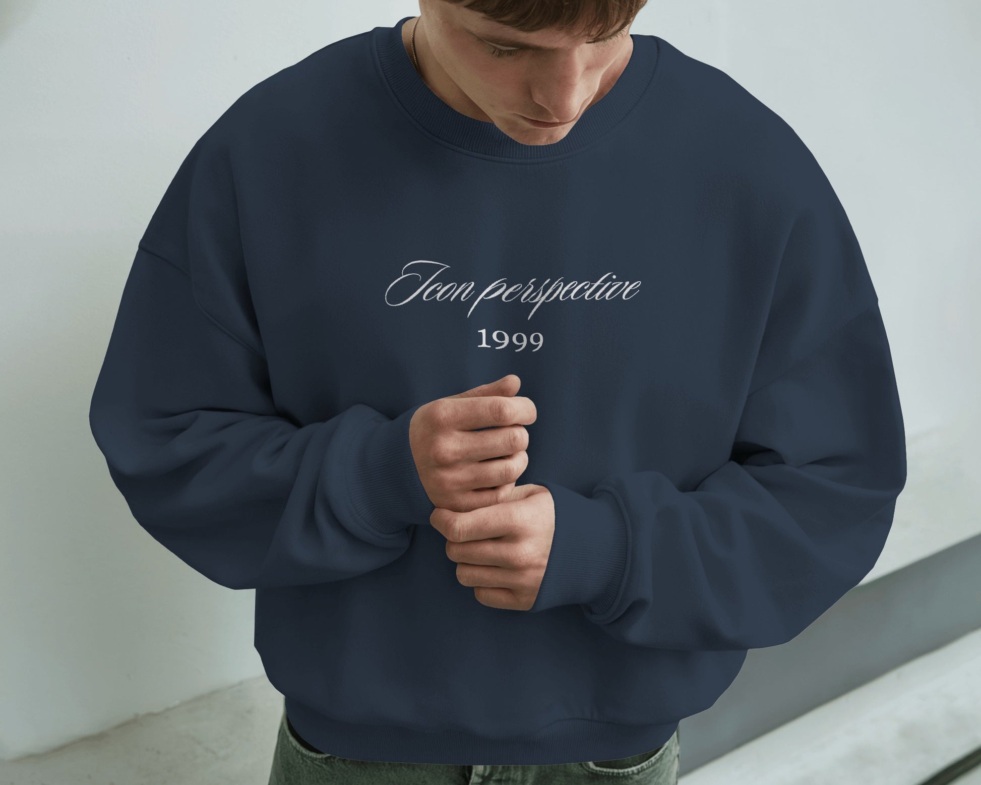 Person wearing a navy blue sweatshirt with text against a light background