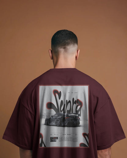 Person wearing a Colour_Maroon t-shirt with a graphic design on the back against a brown background
