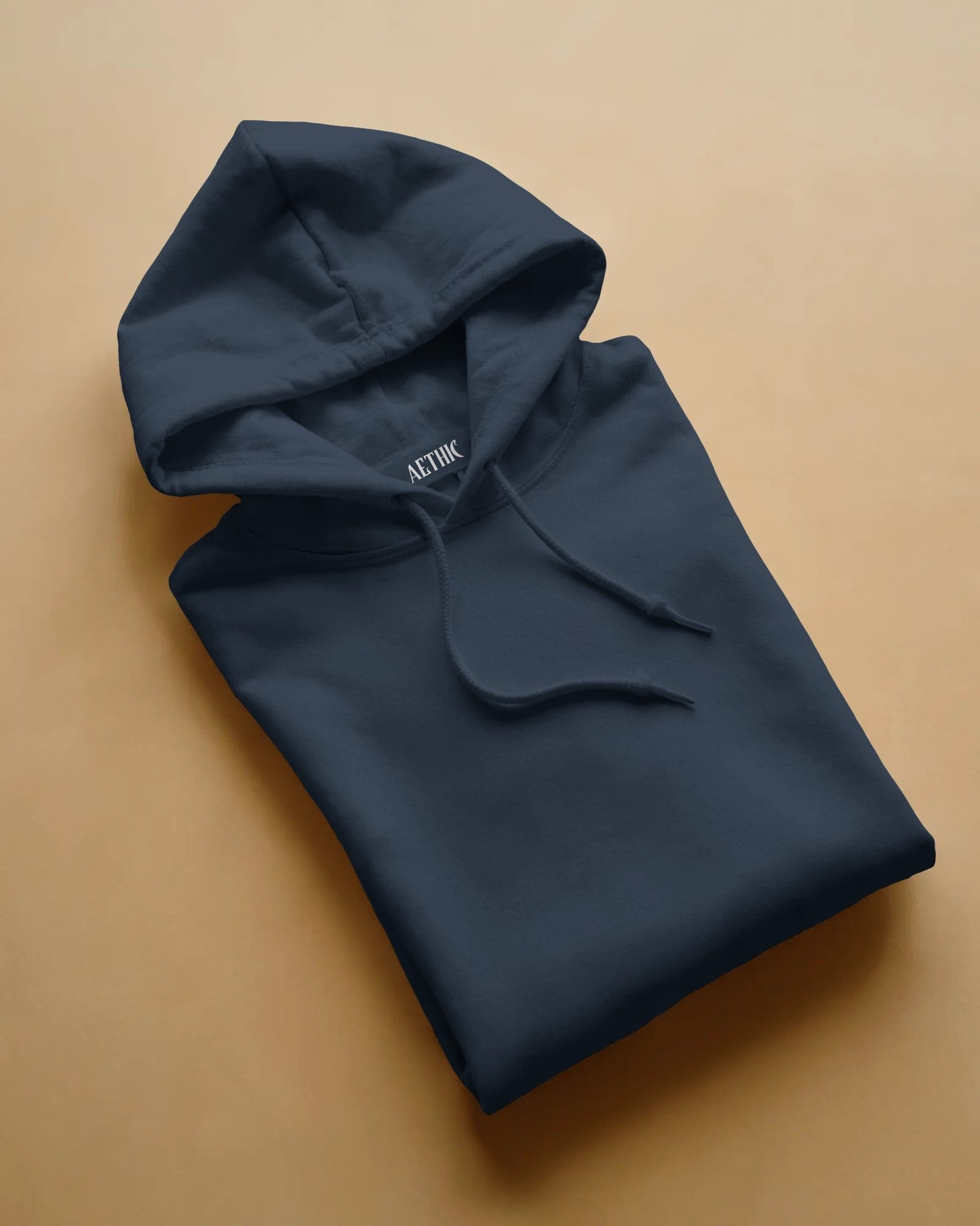 Folded navy hoodie with 'ACTOR' branding on a beige background