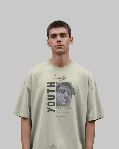Person wearing a light green t-shirt with graphic design and text on a plain background