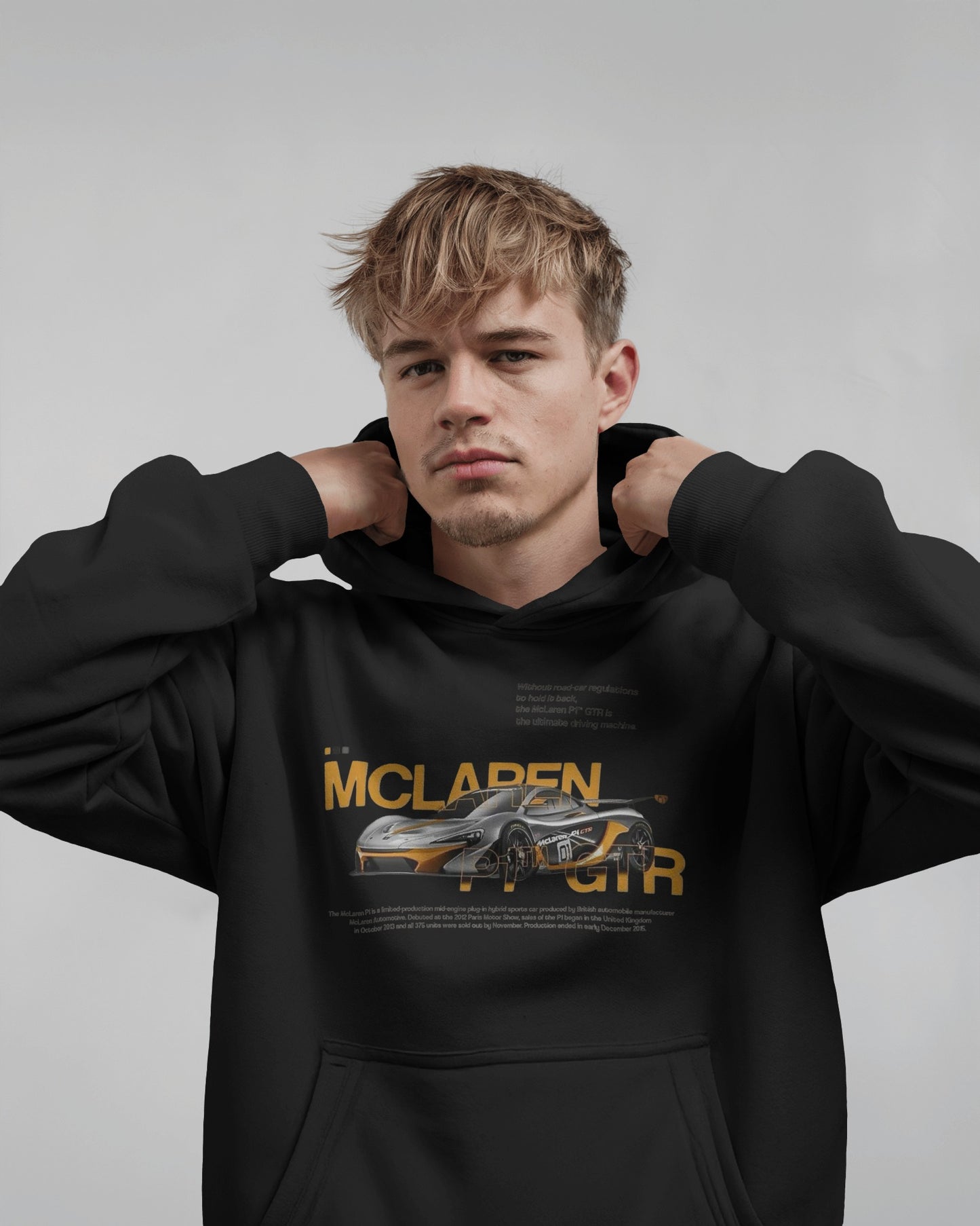 Person wearing a Colour_black  hoodie with McLaren logo and car graphic on a gray background