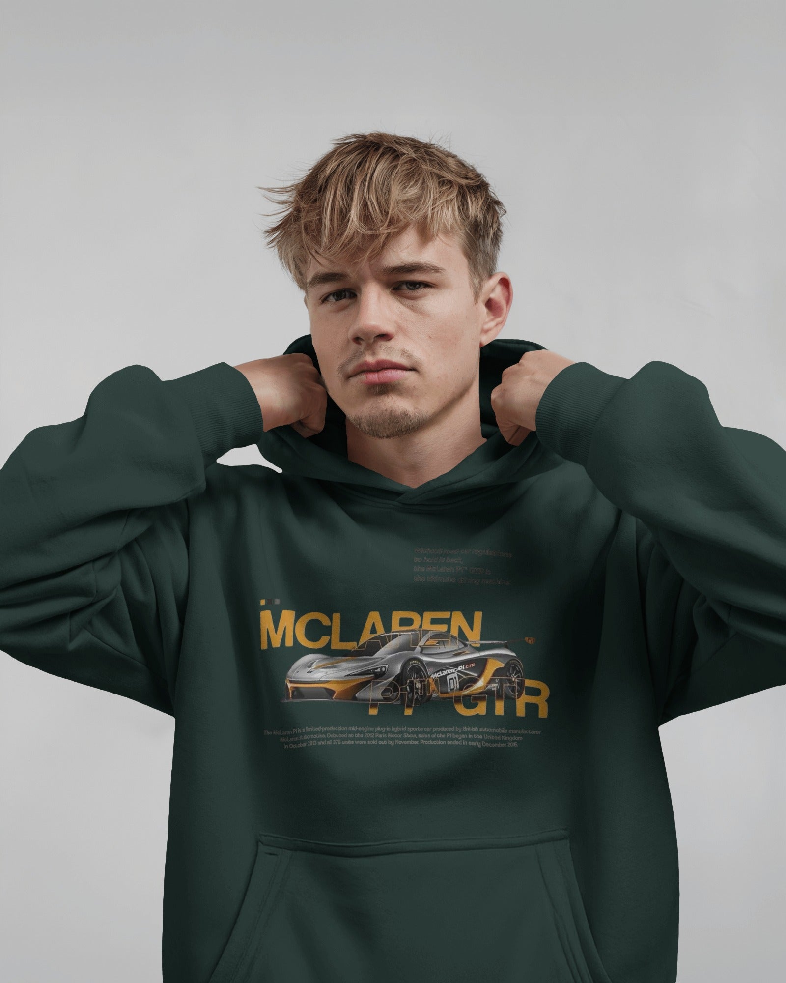 Person wearing a Colour_BottleGreen hoodie with McLaren logo on a gray background